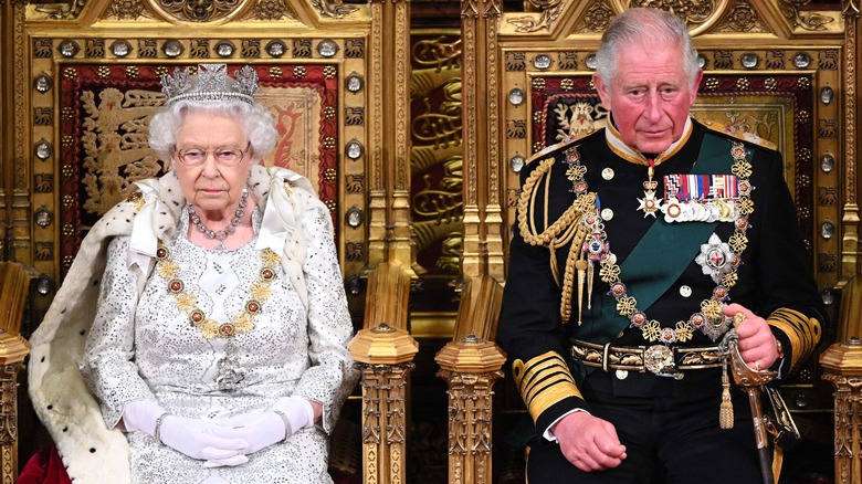 Queen Elizabeth and Prince Charles sitting on thrones
