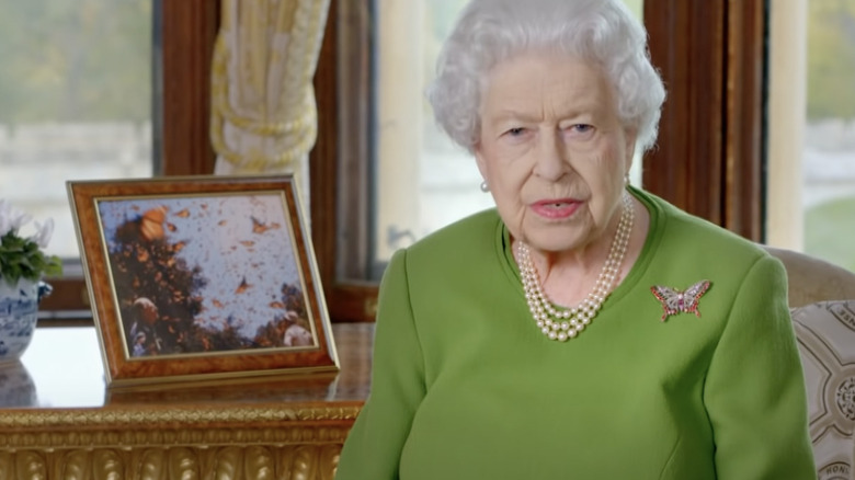 Queen Elizabeth sitting with a photo of Prince Philip