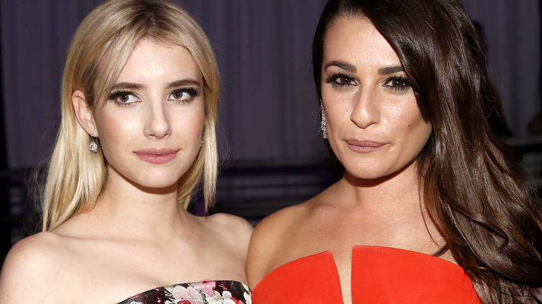 Emma Roberts looking to the side, Lea Michele staring with pursed lips 