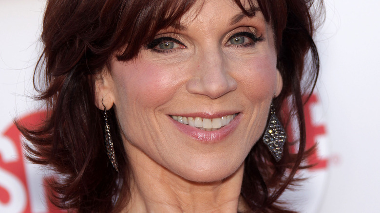 Marilu Henner wears dangling earrings at an event