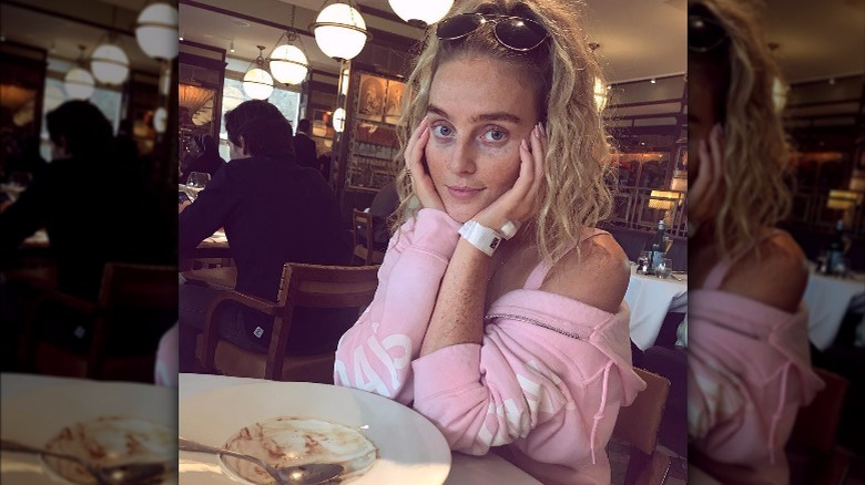 Perrie Edwards with elbows on table 