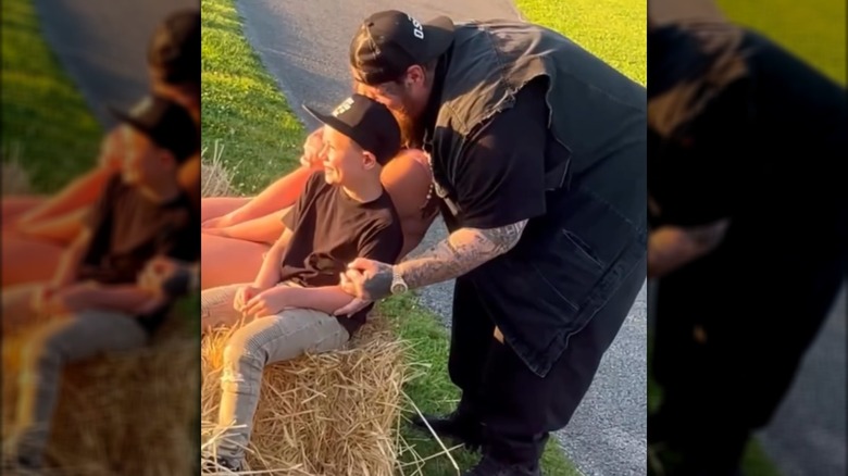 Jelly Roll helps his kids pose on a hay bale.