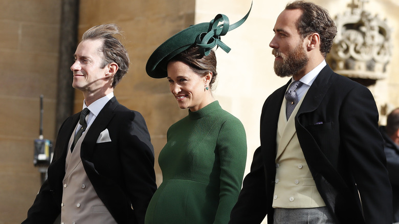 Pregnant Pippa Middleton walking alongside husband James Matthews and brother James Middleton.