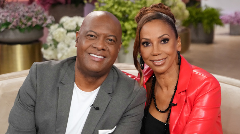 Rodney Peete and Holly Robinson Peete sit on a couch.