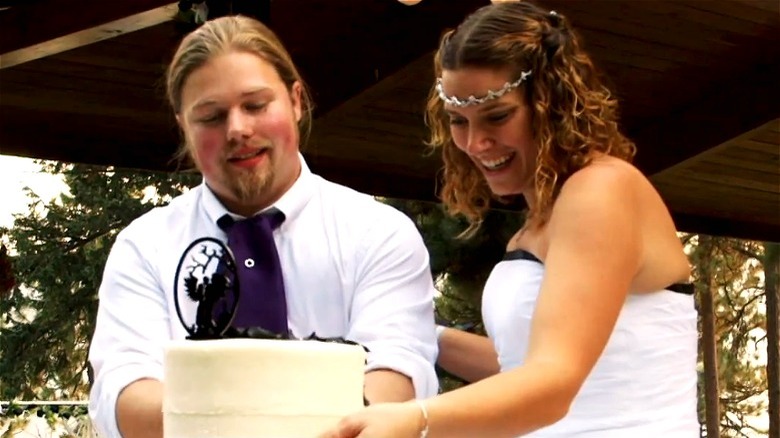 Noah Brown and Rhain Alisha look at wedding cake