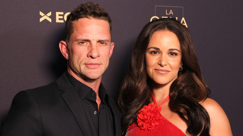 David Fumero wearing black tux; Melissa Fumero beside him in a red dress with floral detail