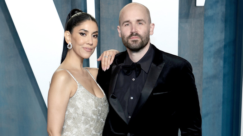 Stephanie Beatriz posing with hand on husband Brad Hoss' shoulder at Vanity Fair party