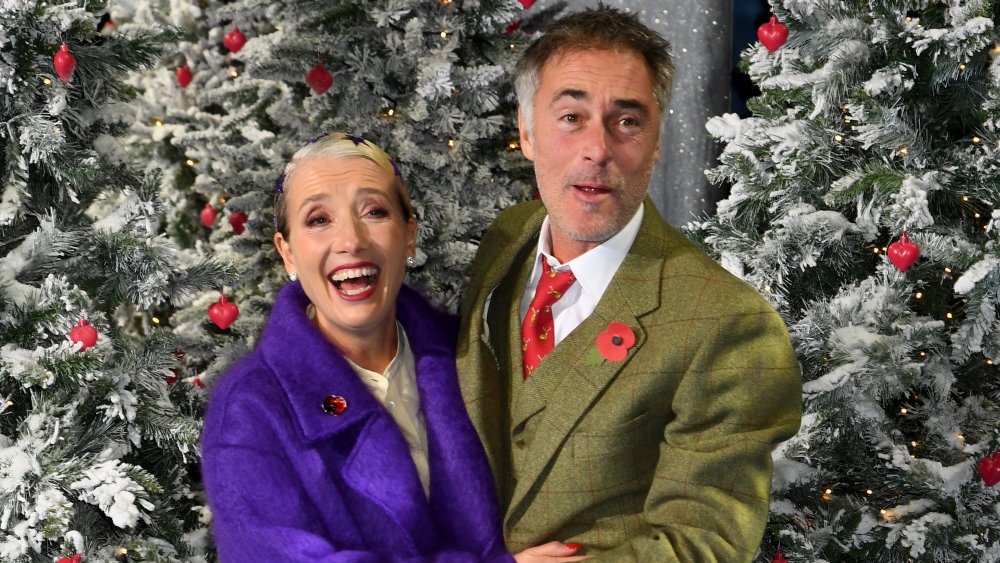 Emma Thompson and Greg Wise in front of Christmas trees