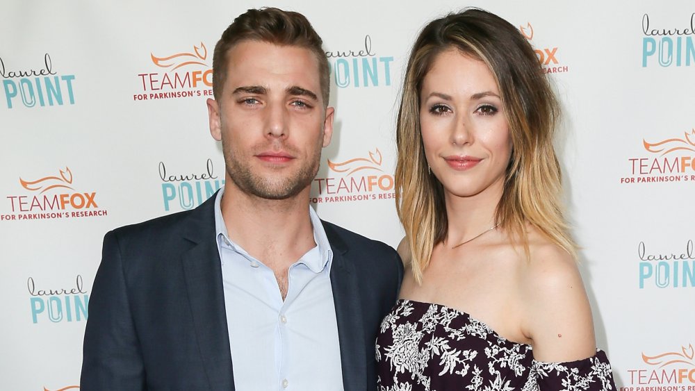 Dustin Milligan and Amanda Crew posing on a red carpet 