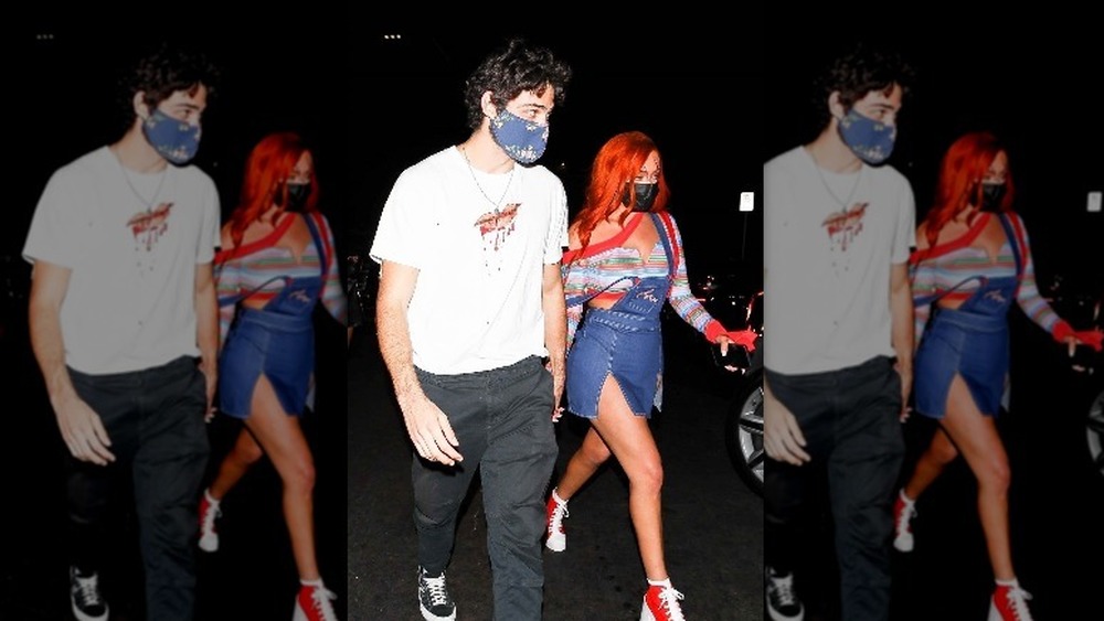 Noah Centineo and Stassie Karanikolaou holding hands at a Halloween party