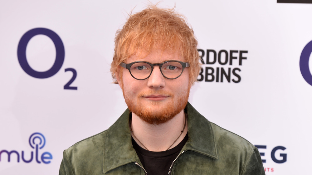 Ed Sheeran posing on the red carpet wearing glasses