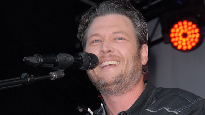 Blake Shelton sings into a microphone