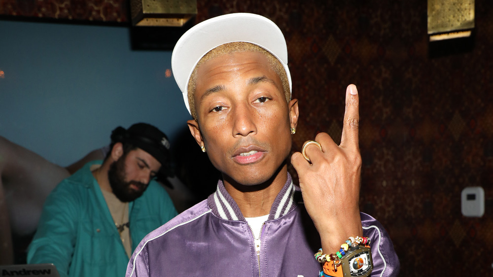 Pharrell Williams gestures at camera