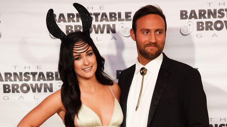 Kacey Musgraves wearing headpiece beside Ruston Kelly