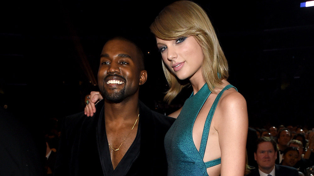Kanye West and Taylor Swift embracing while posing for pictures