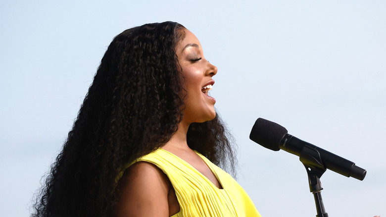 Mickey Guyton sings into a microphone on stage