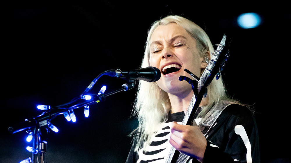 Phoebe Bridgers playing guitar in skeleton suit