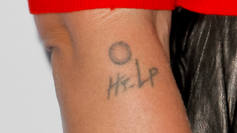 Pink's help button tattoo