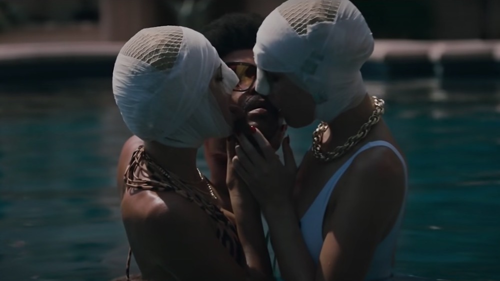 Two models kiss The Weeknd's head in 'Too Late' music video