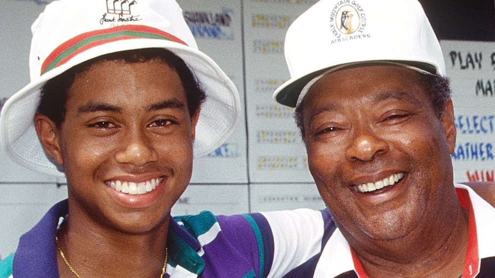 Young Tiger Woods with his arm around his father Earl Woods