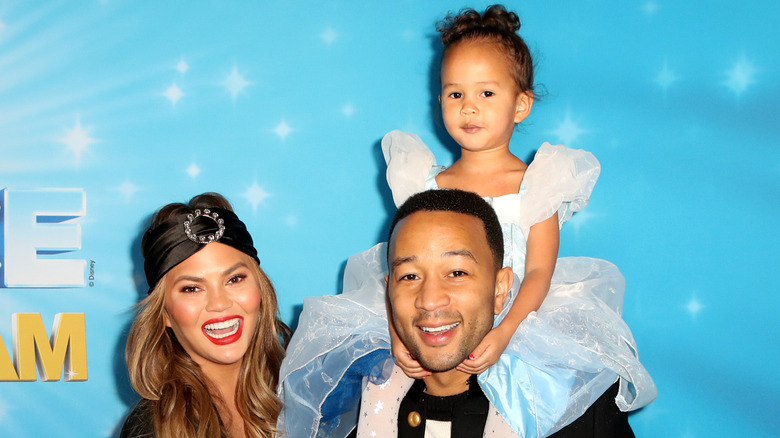 Chrissy Teigen and John Legend with daughter Luna at an event 