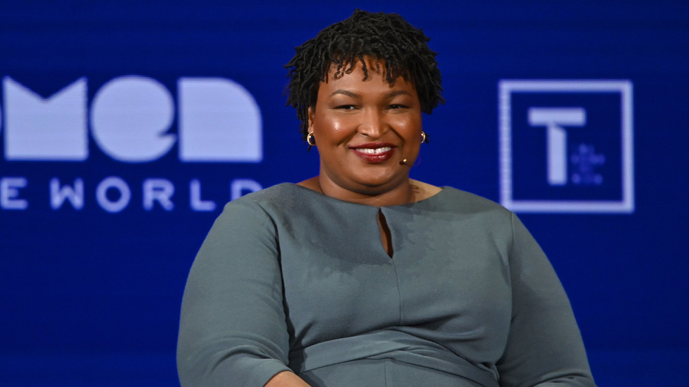 Stacey Abrams smiling while speaking on-stage