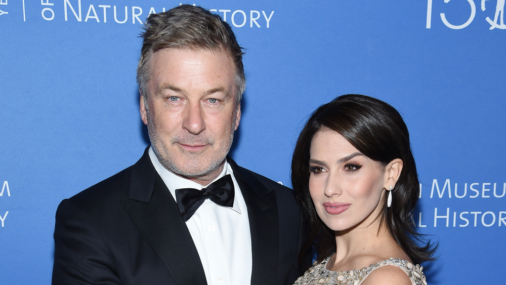 Alec Baldwin posing with wife Hilaria Baldwin who has her hand on his chest