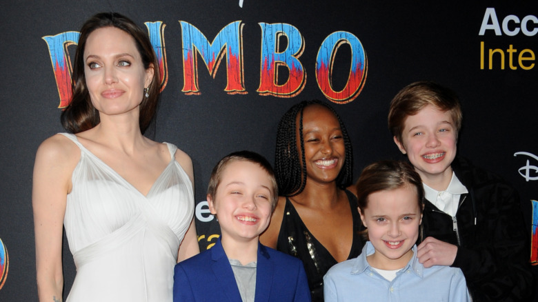 Angelina Jolie posing with her kids at a red carpet event