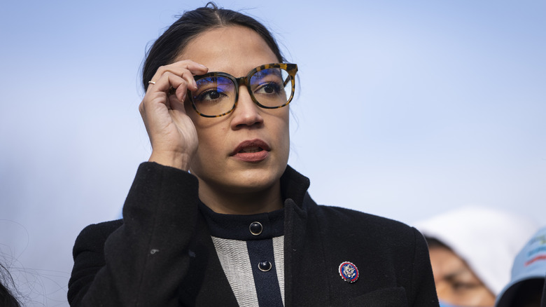 AOC touches her glasses