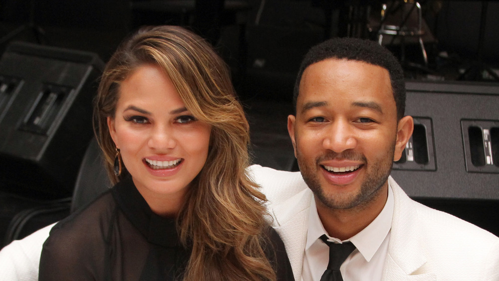 Chrissy Teigen and John Legend, seated and smiling