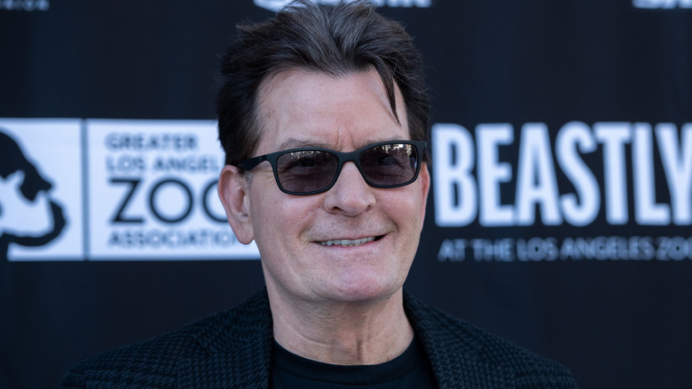 Charlie Sheen smiles in sunglasses