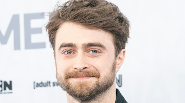 Daniel Radcliffe grins on the red carpet