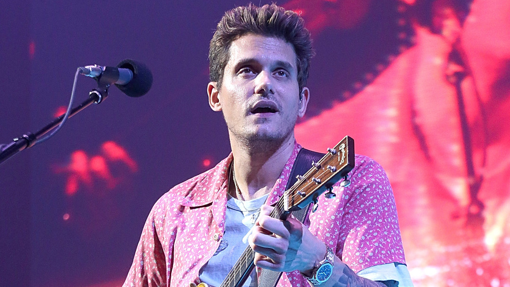 John Mayer looking out into the crowd while performing