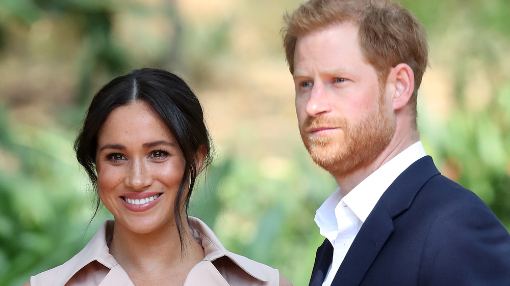 Meghan Markle and Prince Harry looking toward cameras