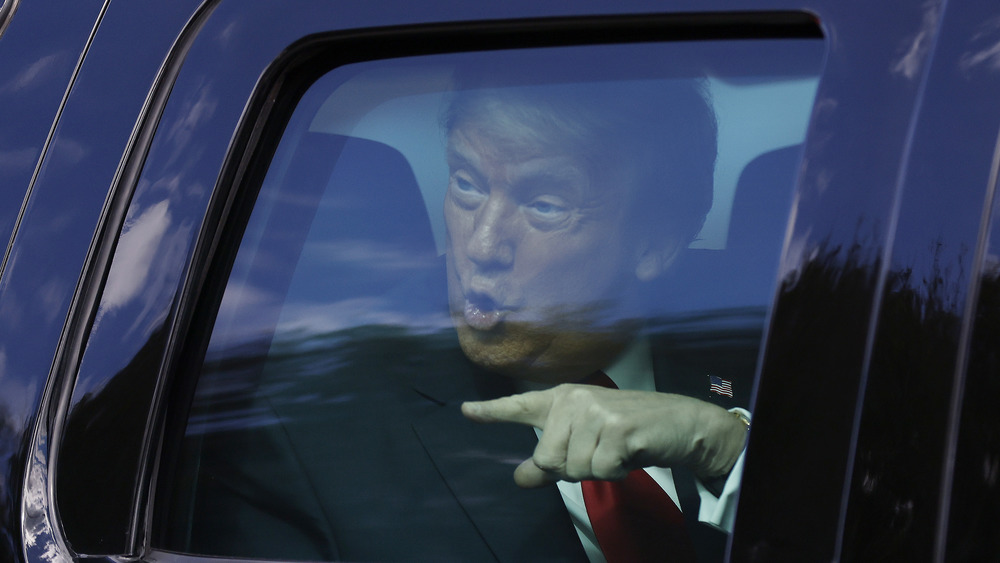 Donald Trump pointing from inside a car