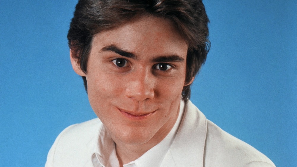 A young Jim Carrey smirking in a portrait session 