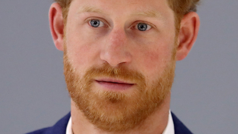 Prince Harry poses in a navy suit