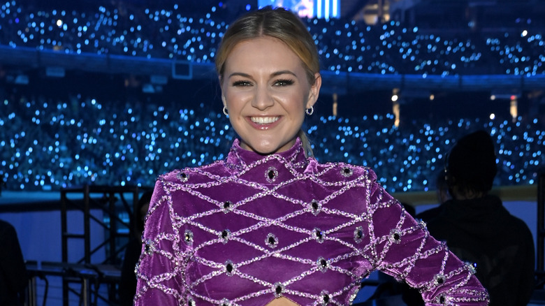 Kelsea Ballerini smiles in a purple top