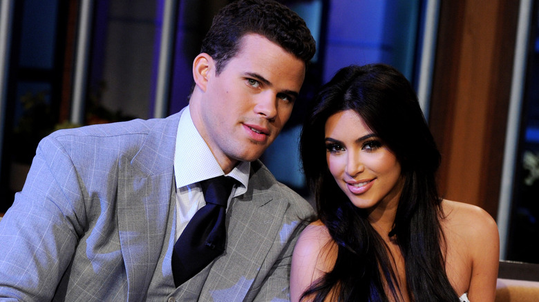 Kris Humphries, looking confused, not smiling, wearing a suit, sitting down next to Kim Kardashian, who is smiling, wearing hair down, 2011 Jay Leno appearance