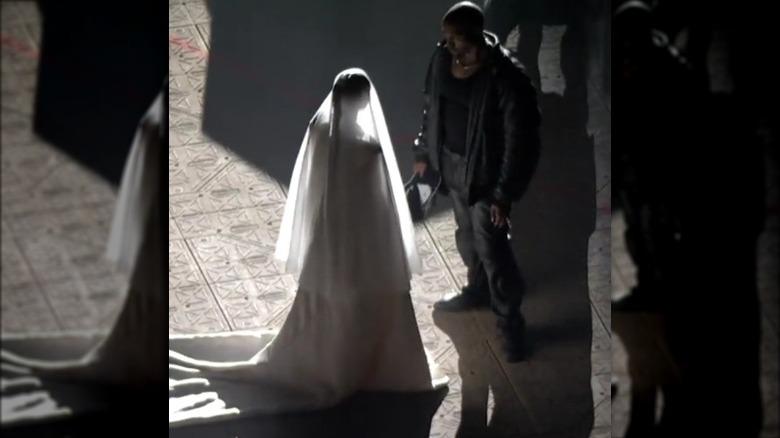 Kanye West watching Kim Kardashian in wedding dress