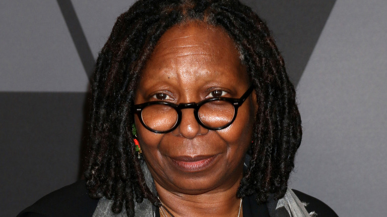 Whoopi Goldberg poses in a black-frame glasses