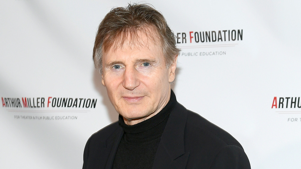 Liam Neeson wearing black posing on the red carpet