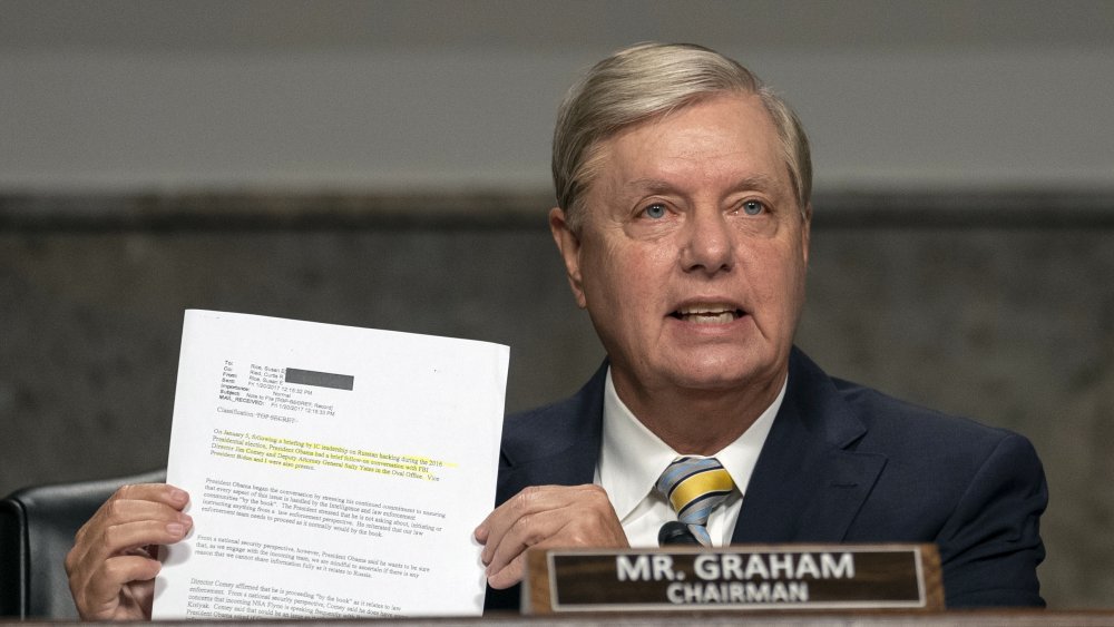 Sen. Lindsey Graham holding up paper work while speaking