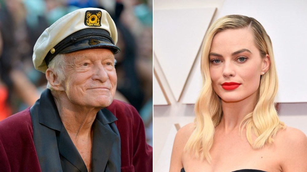 Hugh Hefner in red jacket and Margot Robbie in black