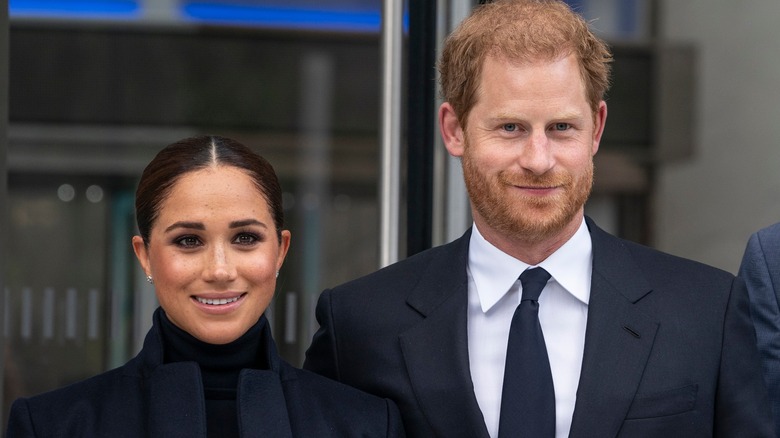 Meghan and Harry smile uncomfortably