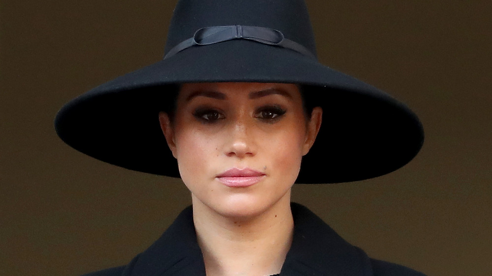 Meghan Markle, the Duchess of Sussex, wearing a hat, looking serious