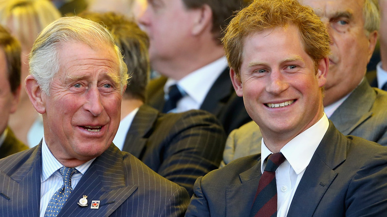 Prince Charles and Prince Harry smiling and talking at the 2018 Invictus games