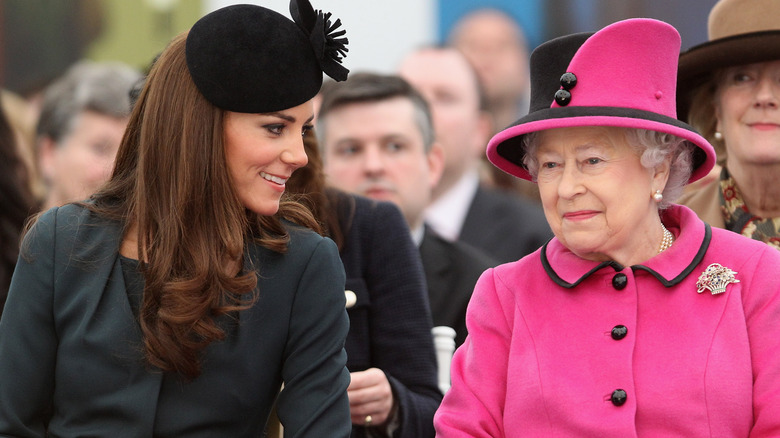 Kate Middleton speaks with Queen Elizabeth at an event