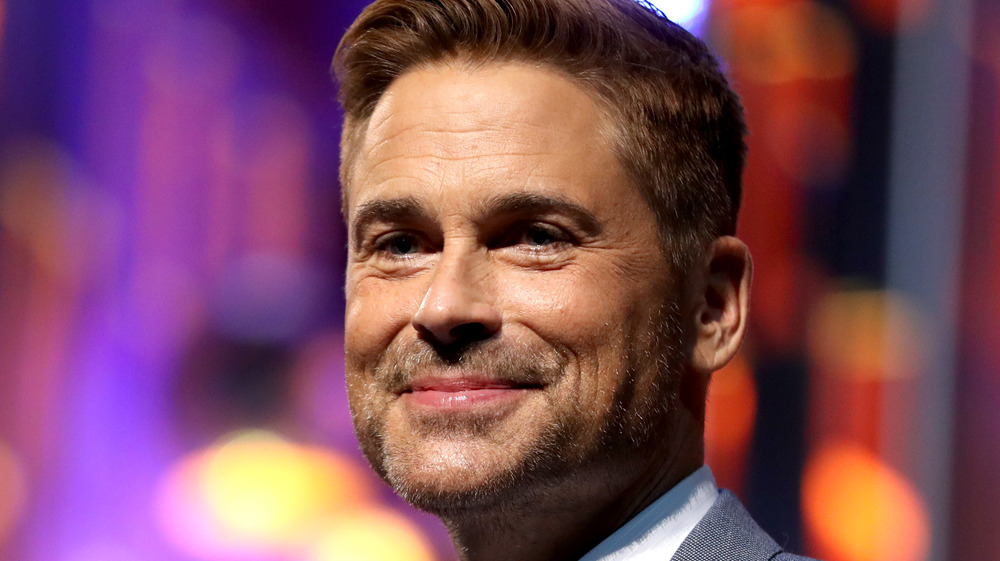 Rob Lowe smiles gently at an event