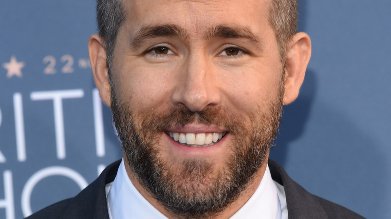 Ryan Reynolds is all smiles in a suit and tie